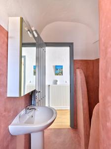 een badkamer met een wastafel en een spiegel bij Amelie Villa with pool and amazing sea views, Paros in Márpissa