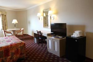 a hotel room with a bed and a desk and a table at Metro Plaza Hotel in Los Angeles
