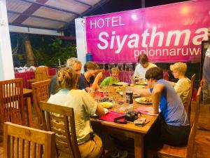 un gruppo di persone sedute a tavola che mangiano cibo di Hotel Siyathma polonnaruwa a Polonnaruwa
