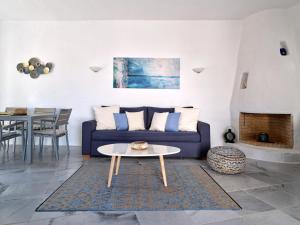 a living room with a blue couch and a table at Amelie Villa with pool and amazing sea views, Paros in Márpissa