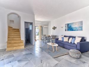 salon z niebieską kanapą i stołem w obiekcie Amelie Villa with pool and amazing sea views, Paros w mieście Márpissa