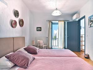 a bedroom with two beds with pink sheets at Amelie Villa with pool and amazing sea views, Paros in Márpissa +41 photos