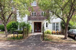 a white house with a porch with a balcony at The West Brompton Collection in London