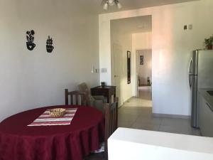 a kitchen with a table with a red table cloth on it at Avenida Departamento completo, cerca de todo in San Nicolás de los Arroyos