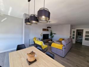 a living room with a table and yellow chairs at Aurora in Ávila