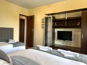 a hotel room with two beds and a flat screen tv at Private Suite at Comfort Bansko in Bansko