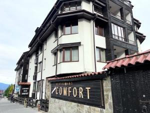 a large white building with a sign in front of it at Private Suite at Comfort Bansko in Bansko