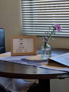 a table with a vase of flowers and a sign on it at Seabreeze Accommodation in L&uuml;deritz