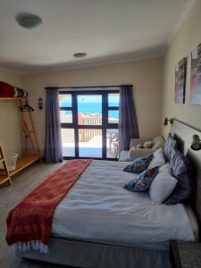 a bedroom with a large bed with a view of the ocean at Seabreeze Accommodation in Lüderitz