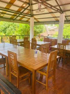 Une grande table et des chaises en bois sont disponibles sur la terrasse. dans l'établissement Hotel Siyathma polonnaruwa, à Polonnâruvâ