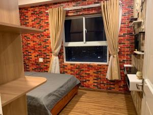 a bedroom with a bed and a brick wall at Homestay 9view thủ Đức in Ho Chi Minh City