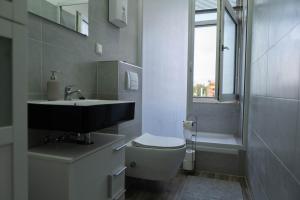 a bathroom with a toilet and a sink and a window at SKY Apartments Hannover in Hannover