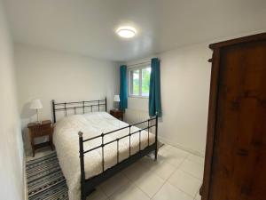 1 dormitorio con cama y ventana en Maison dans parc privé, sports et loisirs proche golf du Coudray Montceaux en Le Coudray-Montceaux