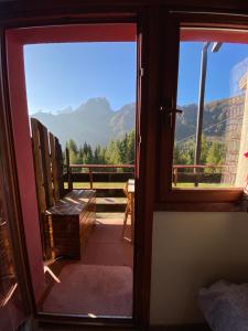 a door to a balcony with a view of mountains at IL COVO DELLO SCIATORE in Falcade