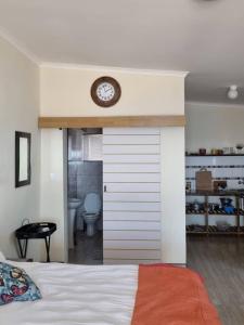 a bedroom with a bed with a clock on the wall at Seabreeze Accommodation in Lüderitz