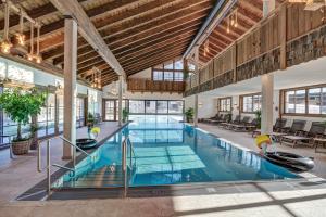 an indoor pool in a building with wooden ceilings at Familien- und Vitalhotel Mühlpointhof in Lofer