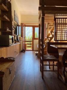 a living room with a wooden floor and a piano at IL COVO DELLO SCIATORE in Falcade