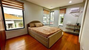 a bedroom with a bed in a room with windows at New Cozy 3 Bedroom House in Davao City +16 photos
