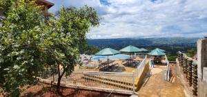 Blick auf einen Pool mit Sonnenschirmen, Tischen und Stühlen in der Unterkunft Angani Resorts & Spa Limited in Shamenei