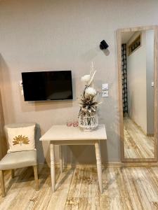 a room with a table and a tv and a chair at Hotel Restaurant Beau Séjour in Morsbronn-les-Bains