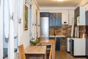 a small kitchen with a wooden table and chairs at Konačište Zaplanjsko ognjište in Donji Dušnik