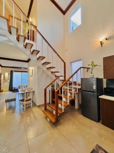 a kitchen and living room with a staircase in a house at Yog Niketan Villa in Rishīkesh
