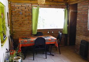 stół i krzesła w pokoju z oknem w obiekcie Refugio Pachalquimia w mieście Bariloche