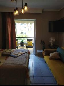 a bedroom with two beds and a window with a chair at Cozy studio, 1min from Kamara in Thessaloniki