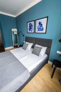um quarto com uma cama grande e paredes azuis em Appartment- Sauran 15 near the Garden em Astana