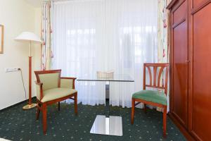 ベンサージールにあるApartments im Nordseegartenparkのテーブルと椅子2脚、窓が備わる客室です。
