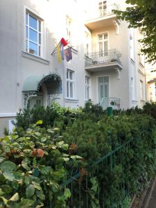 a garden in front of a white building with plants at Apartament Haffnera in Sopot