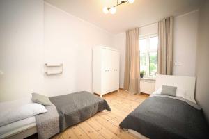 a bedroom with two beds and a window at Apartament Haffnera in Sopot