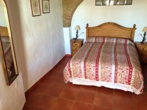 a bedroom with a bed and a tiled floor at Casa Rural El Zaguán in Jimena de la Frontera