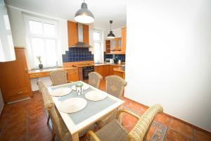 a dining room with a table and chairs in a kitchen at Apartament Haffnera in Sopot