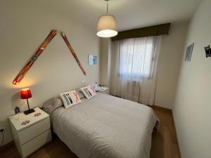 Habitación pequeña con cama y ventana en Precioso apartamento en San Isidro , ski , snow, en San Isidro