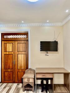 Habitación con puerta y TV en la pared en Arabon Hotel, en Bukhara