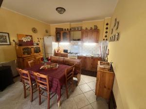 eine Küche mit einem Tisch und Stühlen sowie einem Kühlschrank in der Unterkunft Oasi nel borgo in Aielli