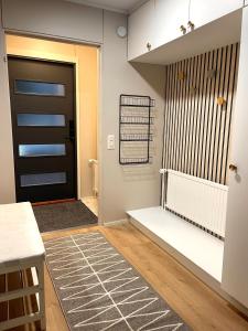 a hallway with a black door and a rug at Pieni omakotitalo joen rannalla in Rautio
