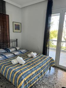 een slaapkamer met een bed met 2 kussens erop bij Wait 'n Sea Apartment by A&D Properties in Porto Rafti
