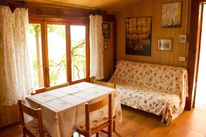 a room with a table and a bed and a window at Chalet with pool and view on the olive groove in Coreglia Antelminelli