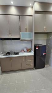 a kitchen with white cabinets and a black refrigerator at SYG12 Homestay Dalur Presint 18 in Putrajaya