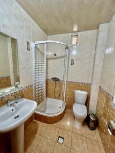 uma casa de banho com um chuveiro, um WC e um lavatório. em Arabon Hotel em Bukhara