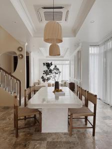 une salle à manger avec une table et des chaises blanches dans l'établissement BeLam in Hue Villa, à Hue