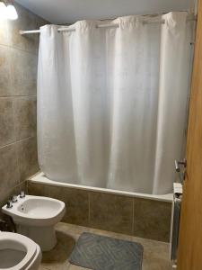 łazienka z białą zasłoną prysznicową i toaletą w obiekcie Tronador w mieście Bariloche