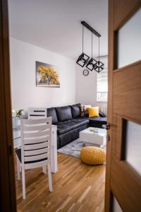 a living room with a couch and a table at Apartman Georgijev with private Free parking in Zlatibor +10 photos