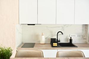 a kitchen with a sink and a counter with white cabinets at pappy home in Pasuljište
