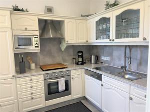 a white kitchen with white cabinets and a sink at Elbhof Wendhausen in Wendhausen