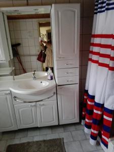 a bathroom with a white sink and a shower at La vecchia Mesnerhaus in Pusterwald