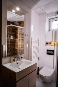 Baño blanco con lavabo y aseo en Apartman Georgijev, en Zlatibor