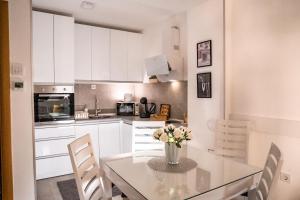 a kitchen with a table with a vase of flowers on it at Apartman Georgijev with private Free parking in Zlatibor